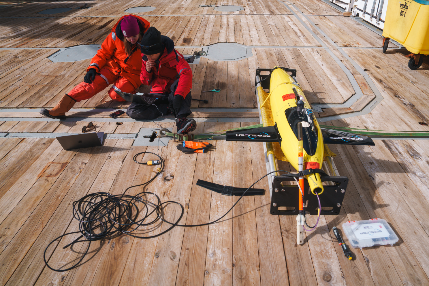 Laura Cimoli (right) and Meredith Meyer (left) make the final communication checks before the deployment of an underwater glider in Antarctica.