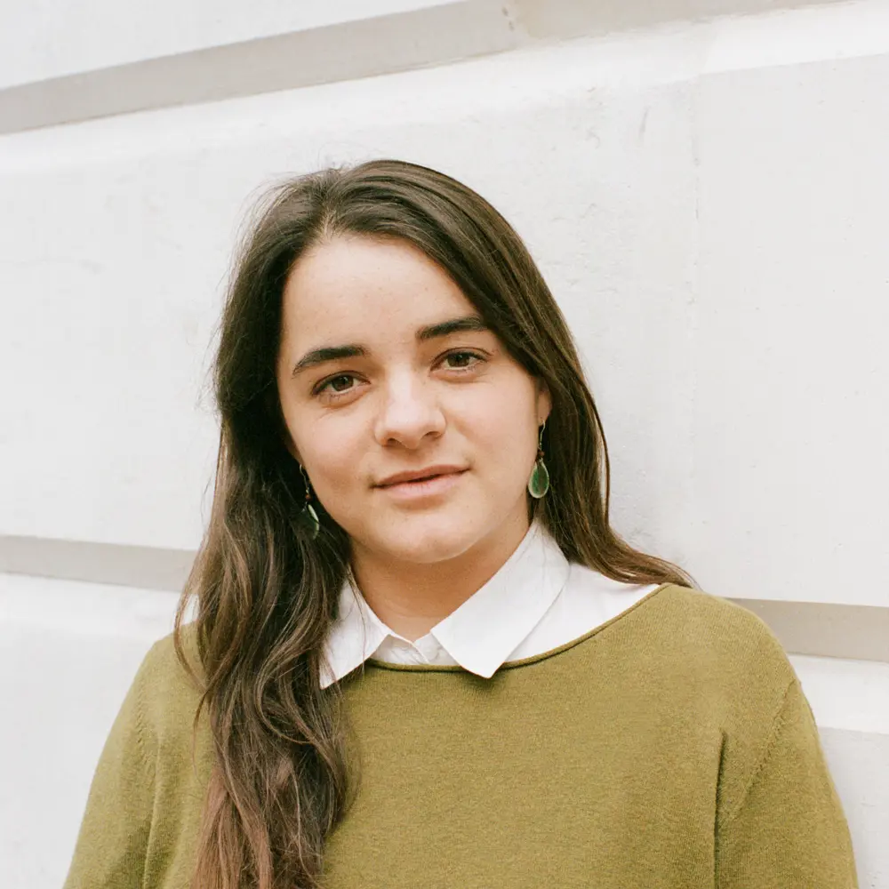 A photo of Nora Ammann smiling at the camera against a white background.